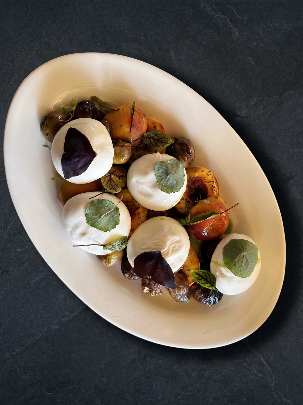 Közlenmiş meyve ve fesleğenle burrata