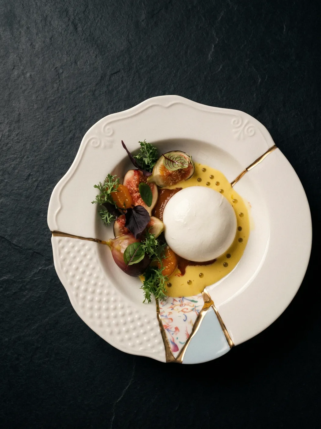 Altın kintsugi tabakta incir ve kayısıyla burrata